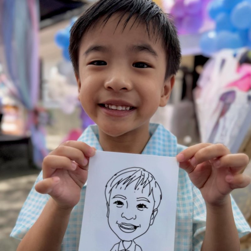 Young guest beaming with their hand-drawn robot caricature at a Robo-Draw event booth